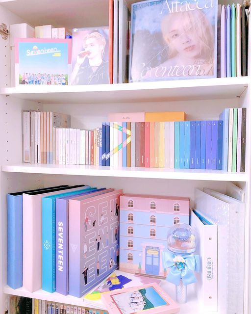 a book shelf filled with lots of books on top of white shelve shelves