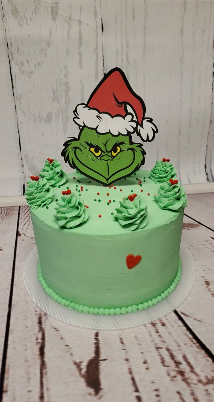 a green cake with an angry grin face on it's top and frosting