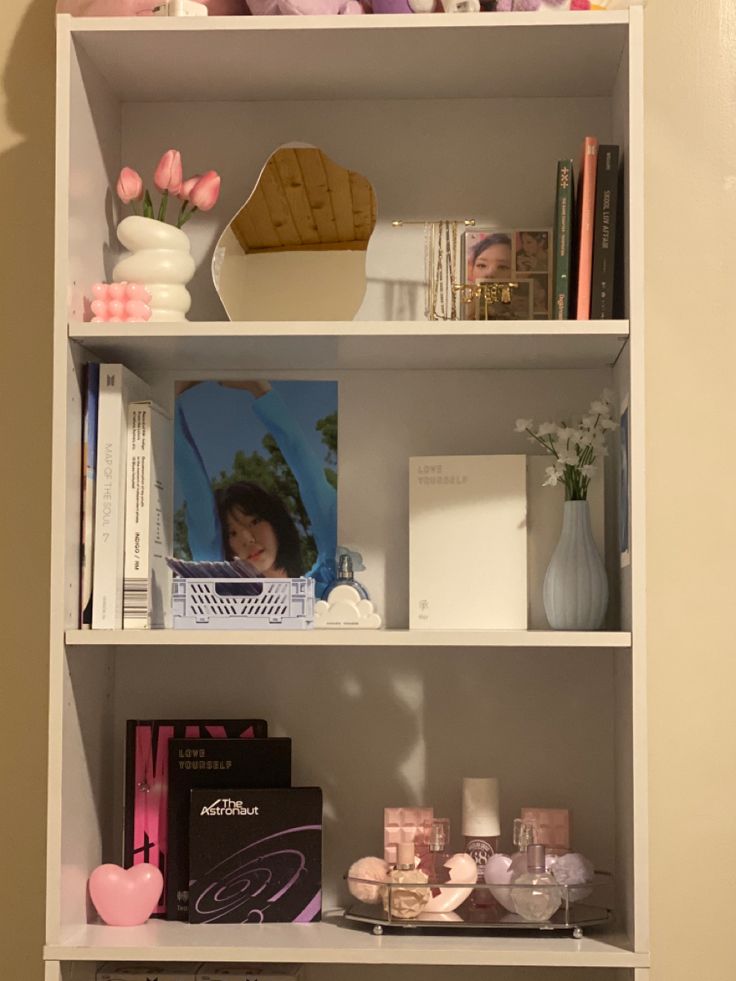 a white book shelf filled with lots of books and other items on top of it