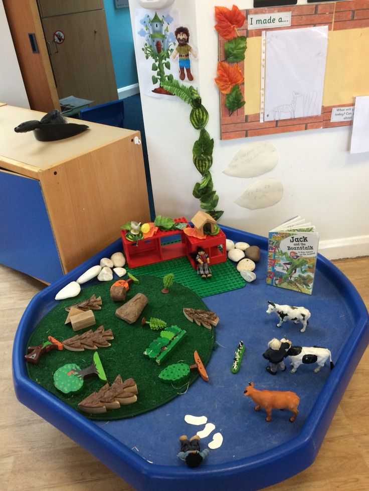 there is a blue tray with toys on it in the middle of a playroom