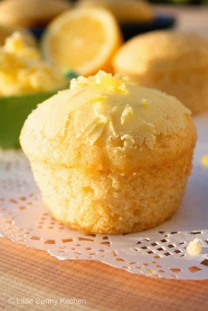 a close up of a muffin on a doily with lemons in the background