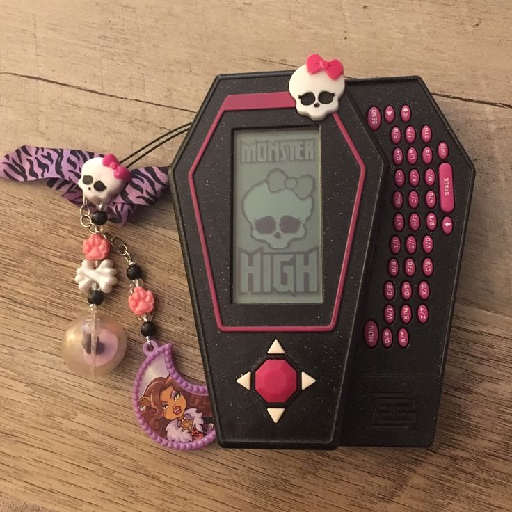 an electronic device with skulls on it sitting on a wooden table next to other items