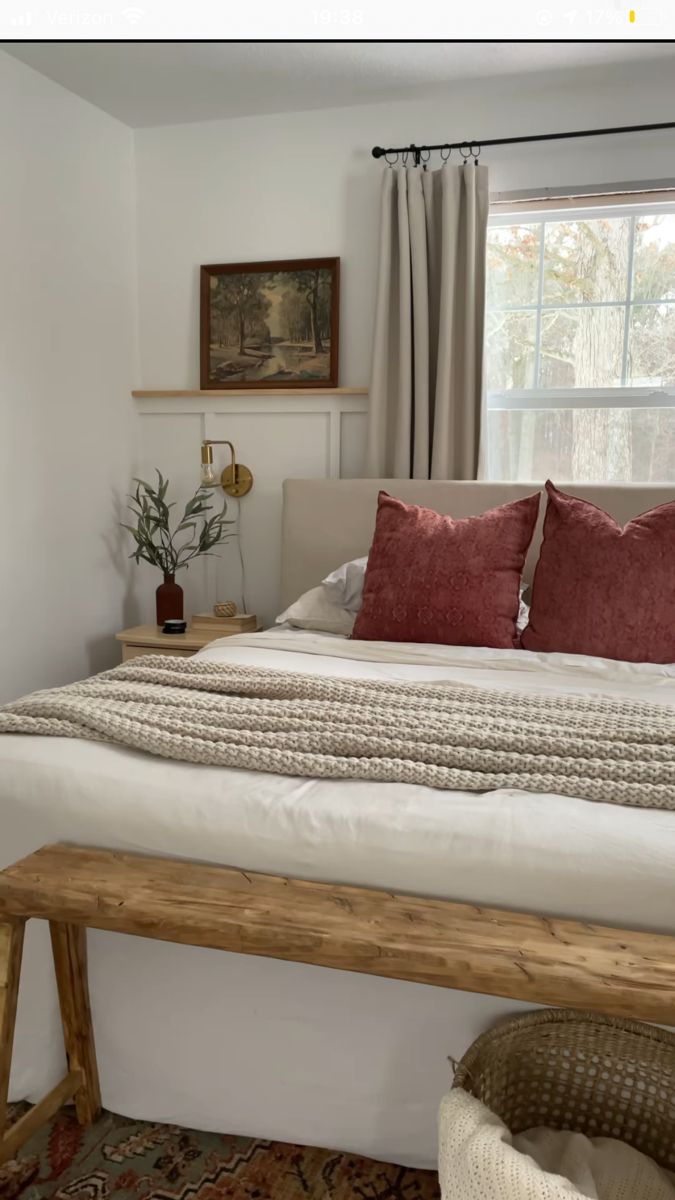 a bedroom with a large bed and wooden bench