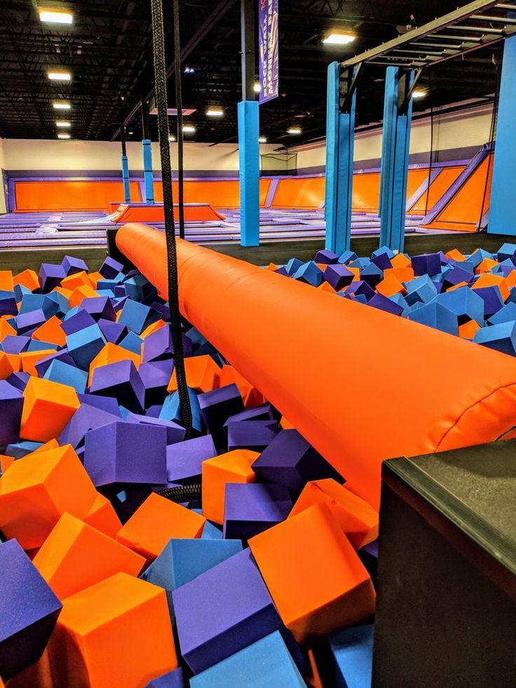 an indoor trampoline filled with orange and blue blocks