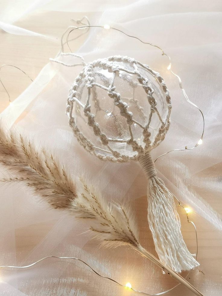 a feather quill and some lights on a white cloth with tulle de lumiee