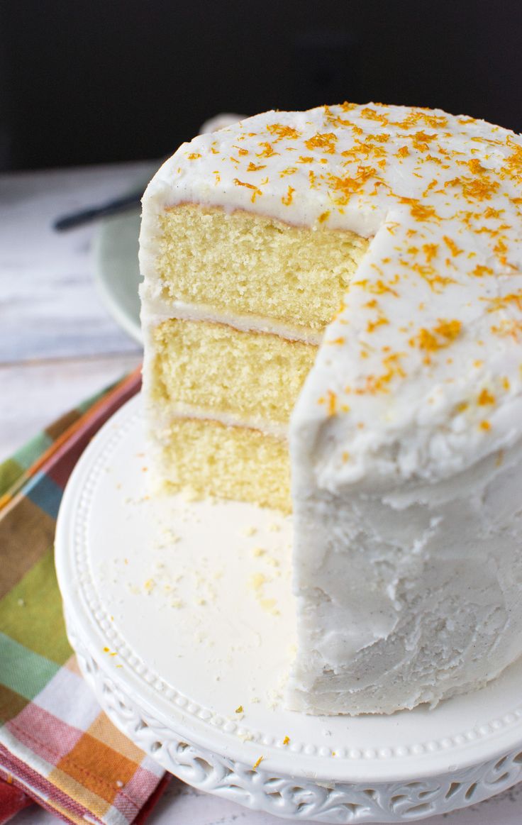 a cake with white frosting and orange sprinkles sits on a plate