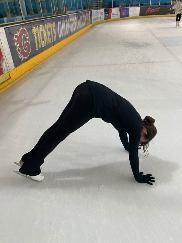 a woman is performing on an ice rink