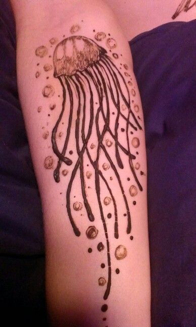 a person with a tattoo on their arm that has a jellyfish and bubbles in it