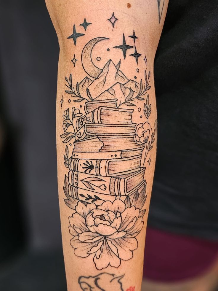 a woman's arm with a stack of books and stars on it