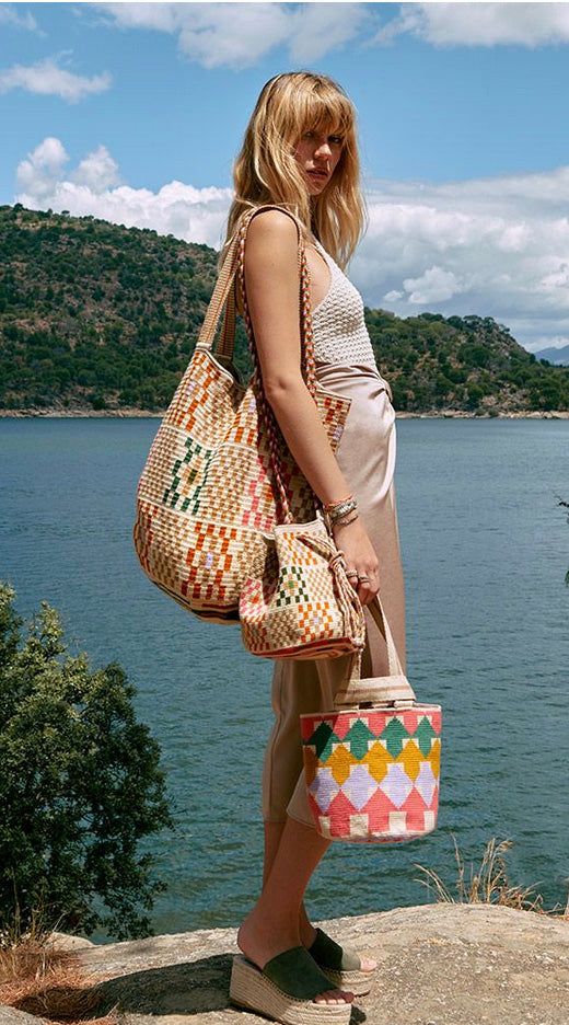 Guanabana's classic tote bag has transformed the classic shopping bag with eye-catching geometric designs and vibrant hues, giving it a unique chic and bohemian vibe. Designed in Madrid and expertly hand-woven by Wayuu artisans in Colombia, this bag features a loose knit and a long, comfortable strap, making it a go-to accessory. The result is a versatile unisex bag that you'll find indispensable. The artisans weave the bases using their designs, so each base is unique and works as their tradema Luxury Sustainable, Classic Tote Bag, Accessories To Make, Blue Tote Bag, Basket Tote, Blue Tote, Loose Knit, Pink Beige, Geometric Designs