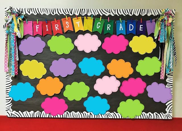 a bulletin board decorated with colorful clouds and rainbow streamers on it's sides