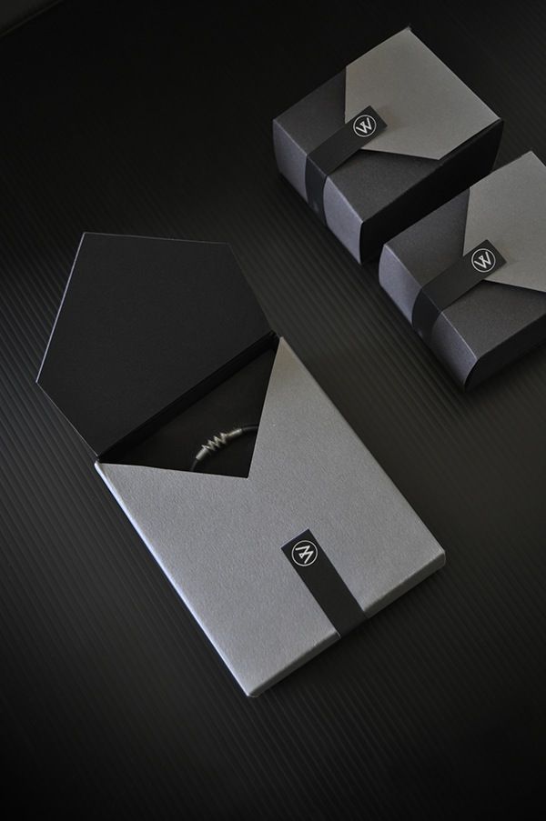 two silver and black business cards sitting next to each other on top of a table