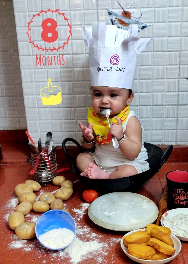 a baby is sitting on the floor with some food in front of him and eating it