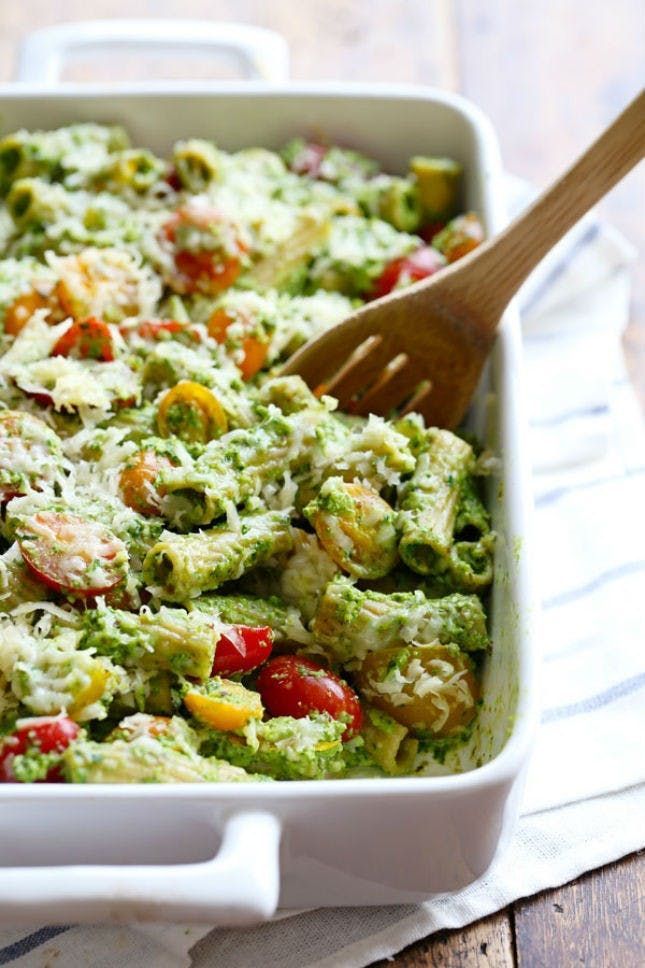 a casserole dish with broccoli, tomatoes and other vegetables in it