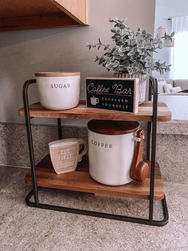 two coffee mugs are sitting on a wooden shelf next to a potted plant