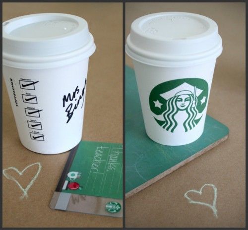 two cups of starbucks coffee sitting on top of a table next to a credit card