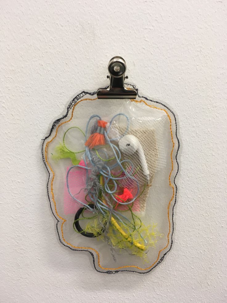 there are many different items in the bag hanging on the wall and it looks like they have been made out of plastic