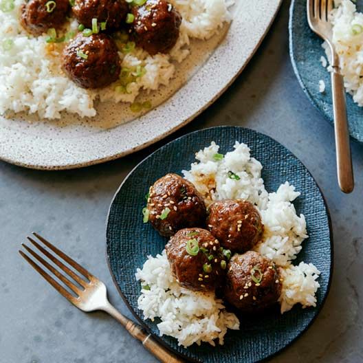 two plates with meatballs and rice on them