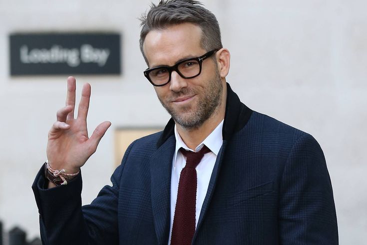 a man in a suit and tie making the peace sign