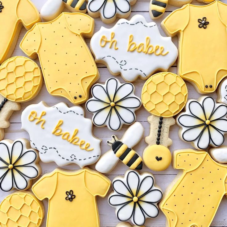 decorated cookies are arranged in the shape of baby ones and bee's on them