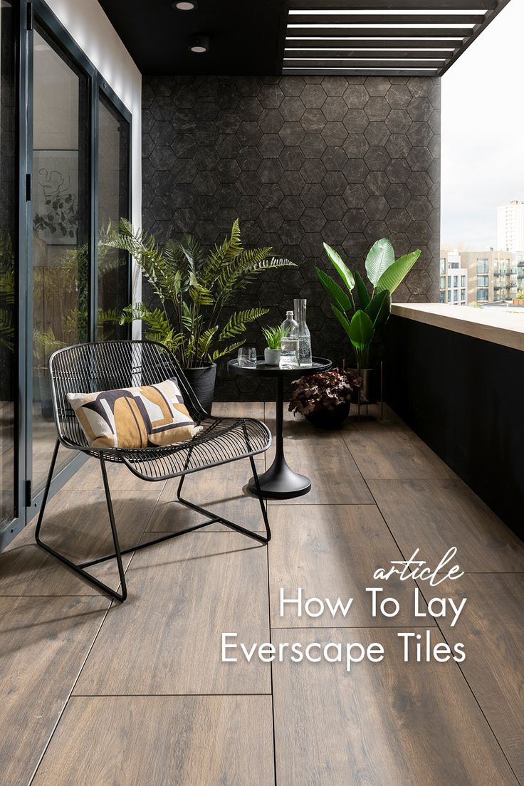 a balcony with a chair, table and potted plants on the floor next to it