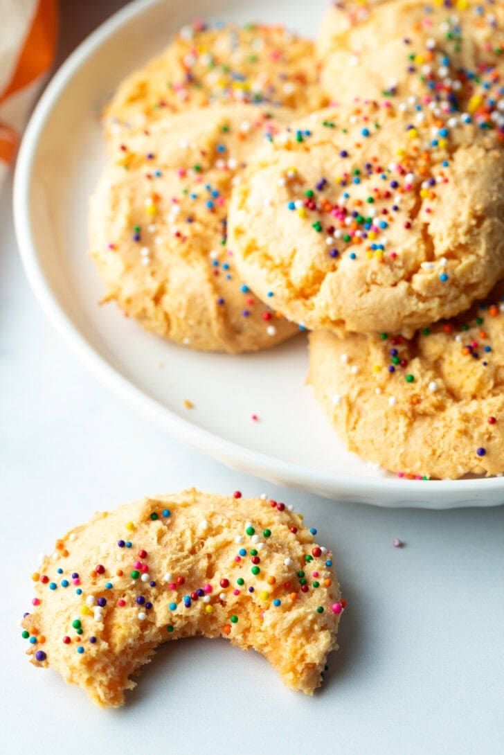 three cookies with sprinkles on a white plate