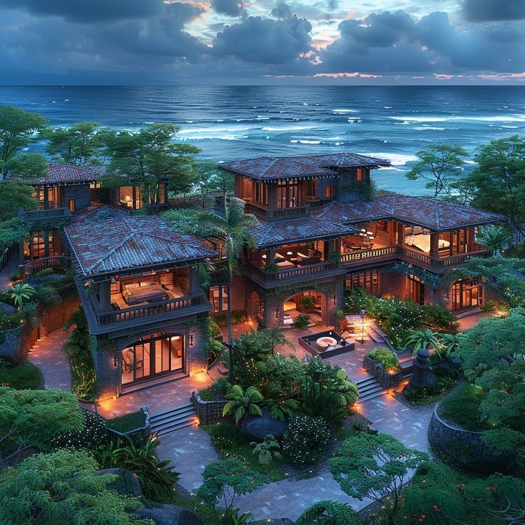 an aerial view of a house on the beach at dusk with ocean in the background