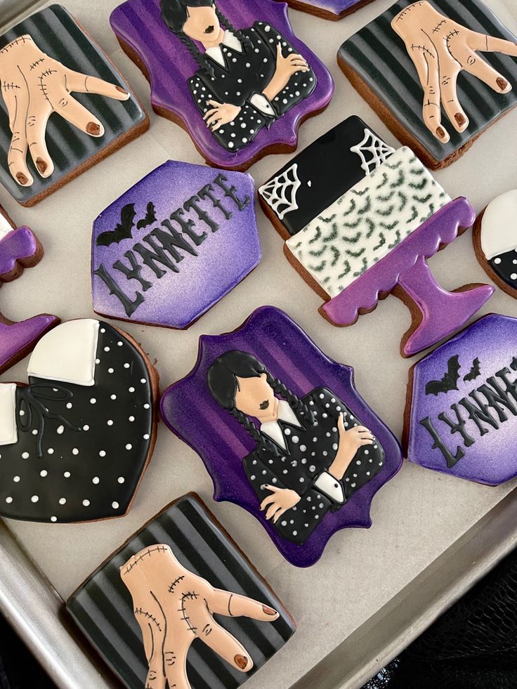 decorated cookies in the shape of women's hands and feet on a tray with purple icing