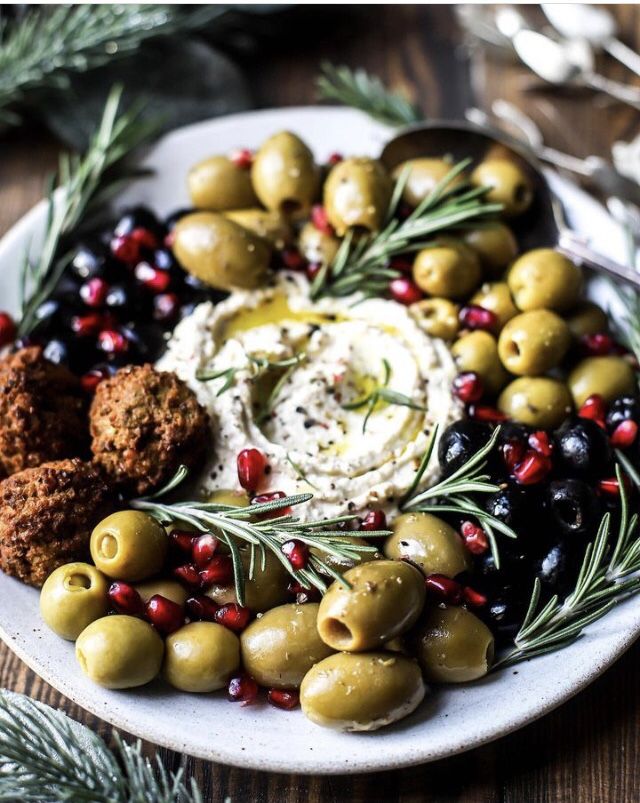 a white plate topped with olives and other foods