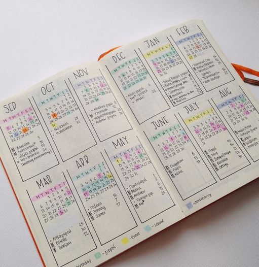 an open planner with the dates on each page and numbers in different colors are shown