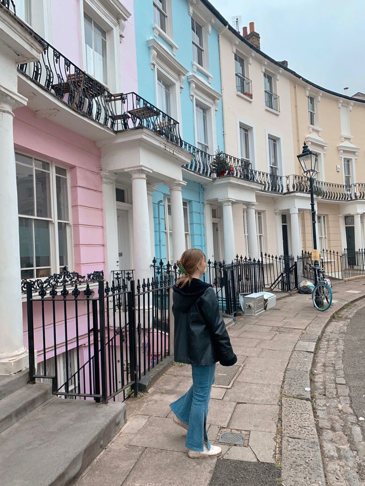 a woman walking down the sidewalk in front of row houses