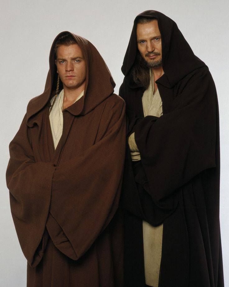 two men dressed in costumes standing next to each other, one wearing a brown robe