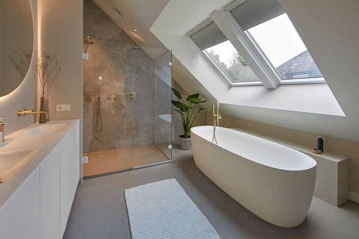 a bathroom with a large bathtub next to a sink under a slanted window