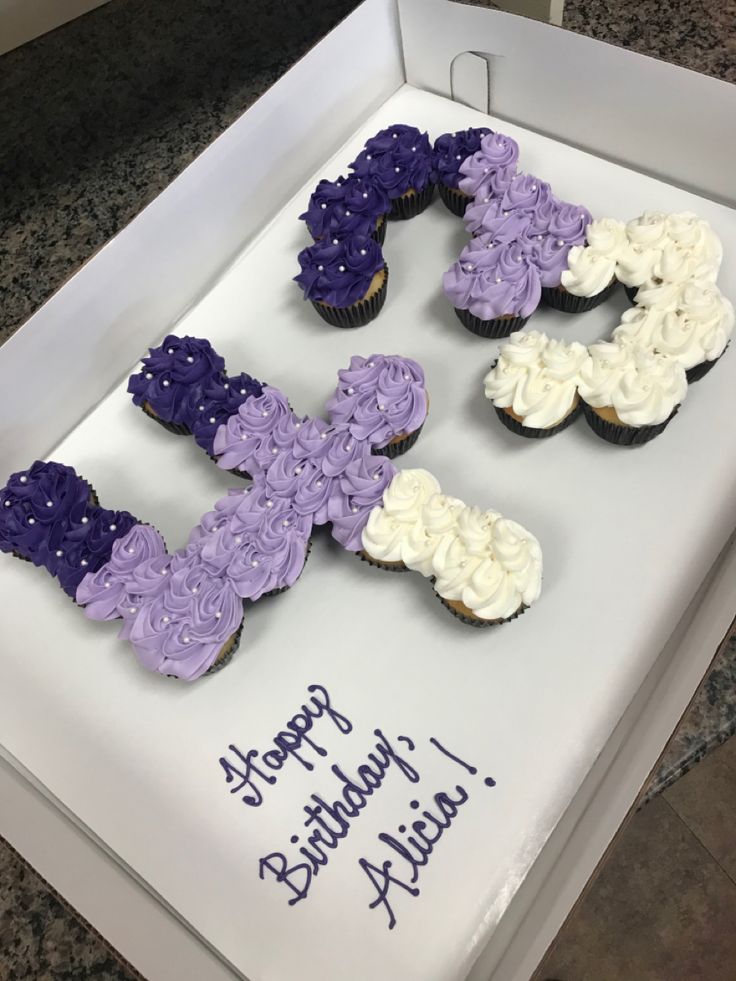 the cupcakes are decorated with purple, white and blue frosting in the shape of letters