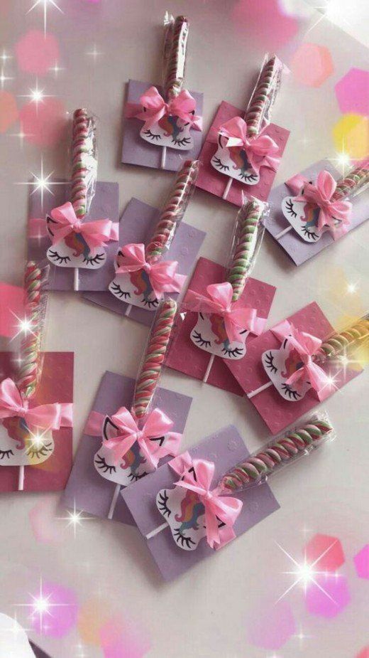 pink and white candy sticks with bows on them are arranged in the shape of unicorns