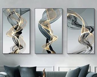 three abstract paintings hanging on the wall in a living room