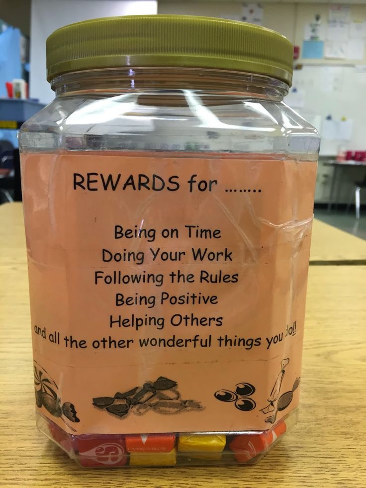 a jar filled with some kind of food on top of a wooden table in a classroom