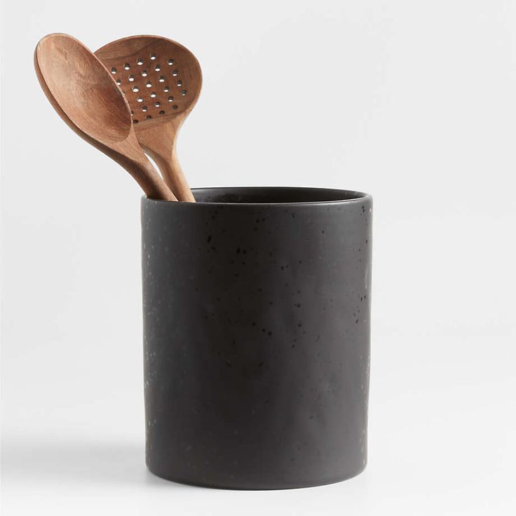 two wooden spoons in a black cup