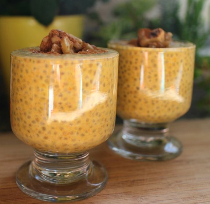 two glasses filled with pudding on top of a wooden table