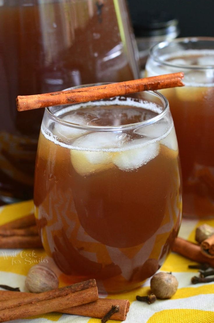 two glasses filled with liquid and cinnamon sticks