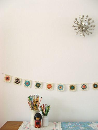 a table topped with a vase filled with pencils next to a wall mounted clock