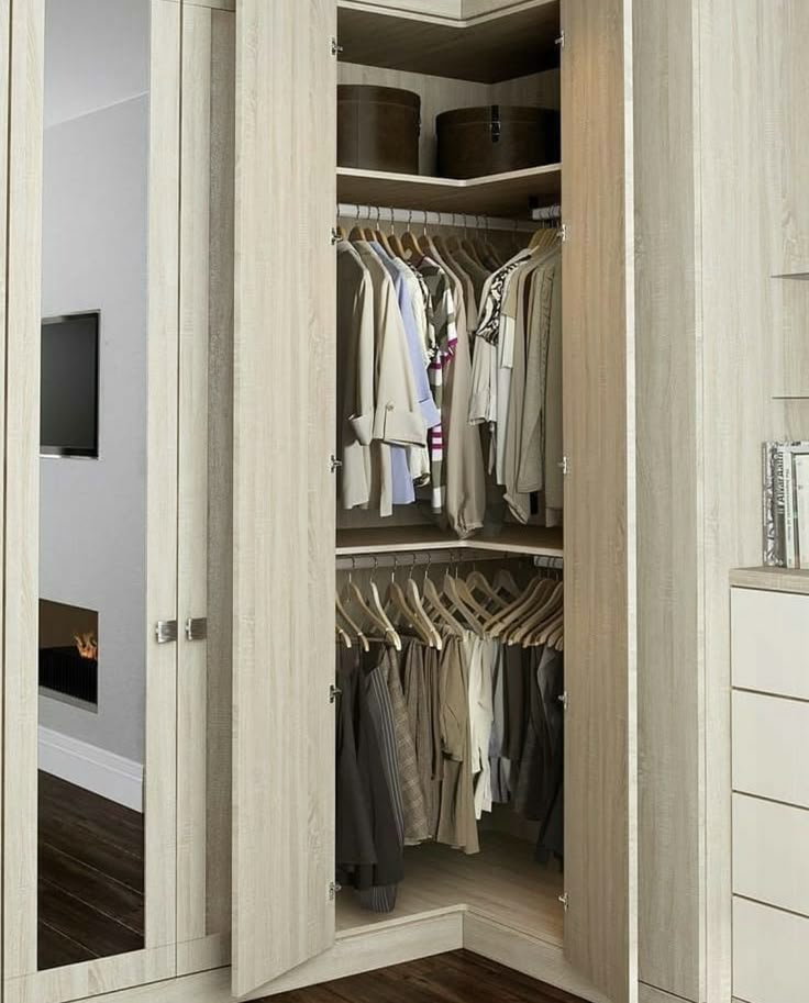 an open closet with clothes hanging in it