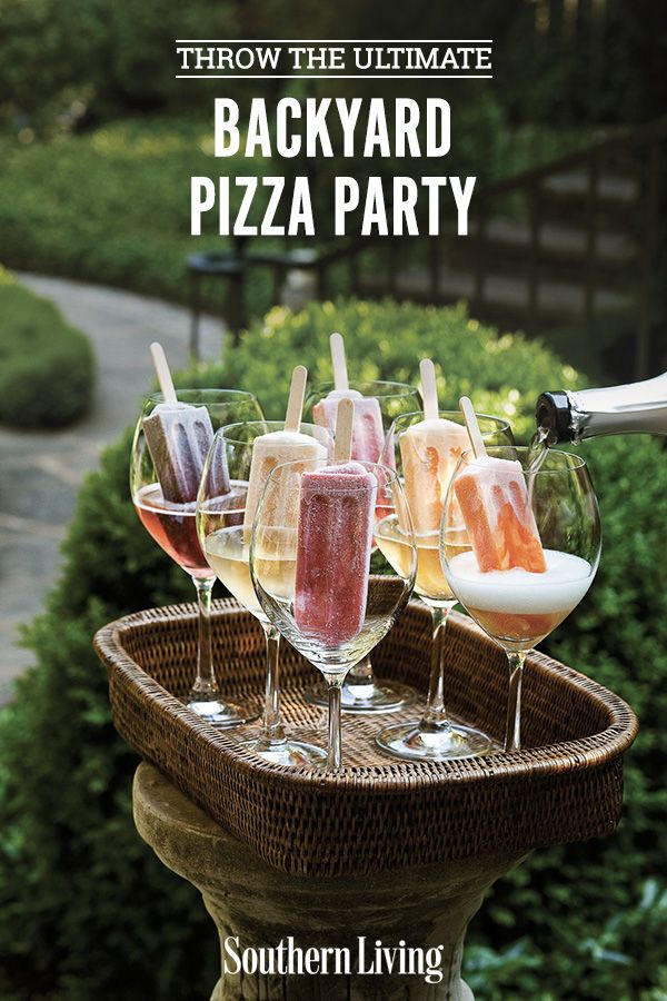 several glasses filled with different types of drinks on a tray in front of some bushes