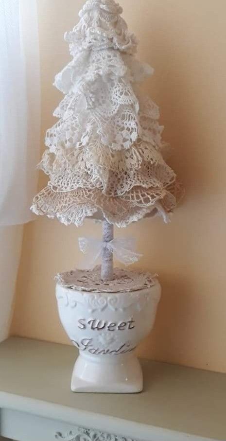 a small white christmas tree sitting on top of a shelf