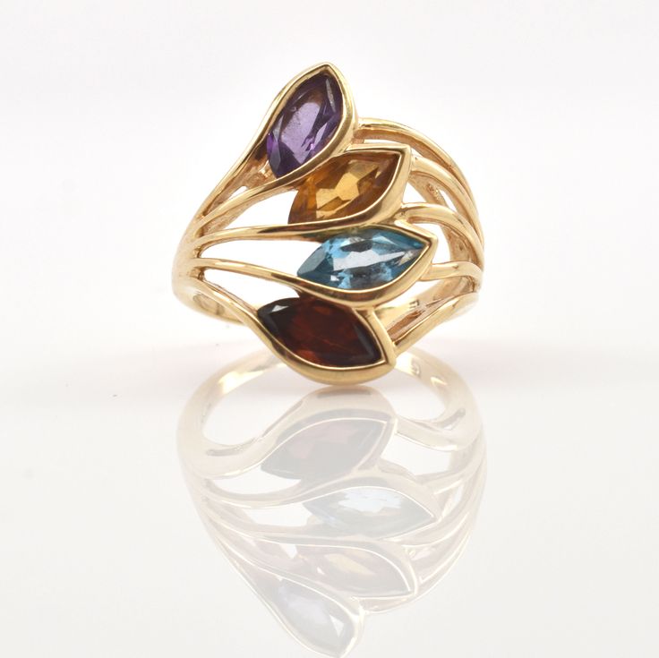 Exquisite 14 karat solid yellow gold ring bezel-set with four marquise-cut gemstones (amethyst, citrine, blue topaz, and garnet), each measuring approximately 7.78 millimeters long by 3.73 millimeters wide and weighing a total of 2.59 carats. The ring is approximately a size 4 1/2, and can be re-sized to fit by your local jeweler. It weighs approximately 5.33 grams. It is stamped 14KP, where the P stands for Plumb, or exactly 14 karat. Excellent estate condition. This ring is a perfect Mother's Gold Marquise Birthstone Ring With Gemstone, Gold Marquise Birthstone Ring, Yellow Gold Marquise Multi-stone Jewelry, Gold Marquise Amethyst Ring Fine Jewelry, Gold Multi-stone Marquise Cut Jewelry, Gold Marquise Amethyst Gemstone Ring, Gold Marquise Amethyst Ring, Gold Amethyst Marquise Ring, Marquise Cut Multi-stone Yellow Gold Jewelry