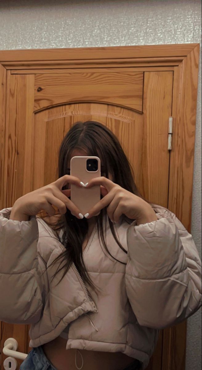 a woman taking a selfie in front of a mirror with her phone up to her face