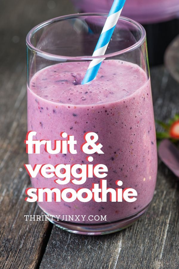 fruit and veggie smoothie in a glass on a table with strawberries