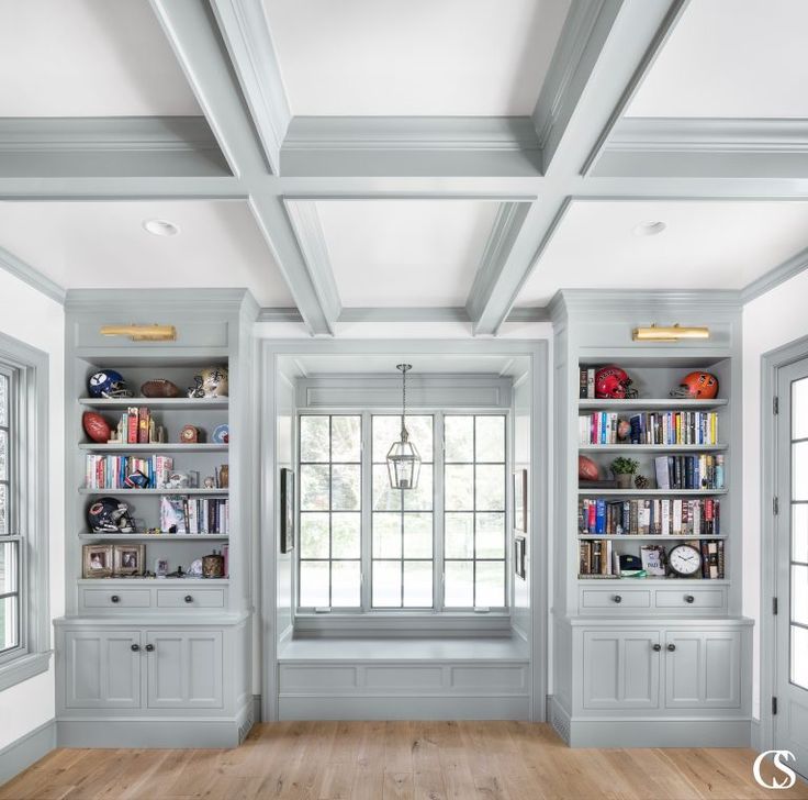 an empty room with white bookcases and wood flooring is pictured in this image