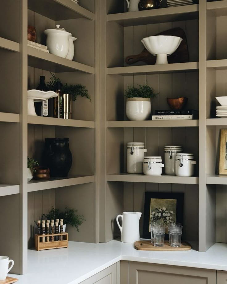 the shelves are filled with dishes and cups