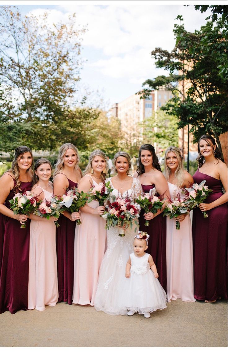 a group of women standing next to each other holding bouquets in front of them